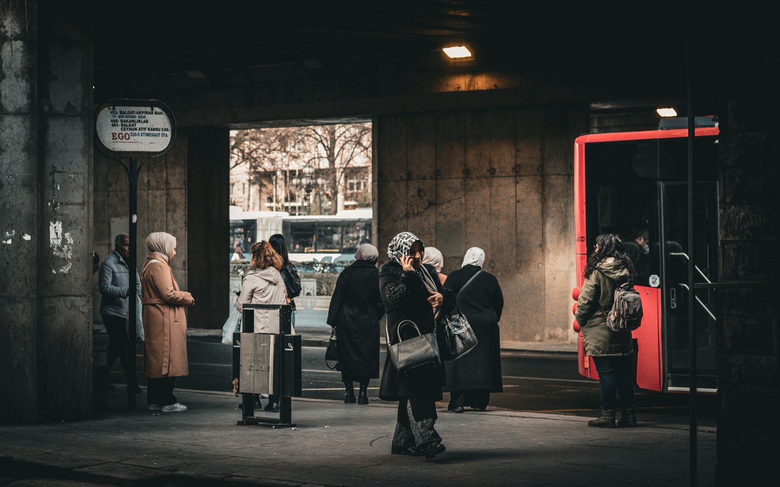 a bus station at dawn, headlights and steam
